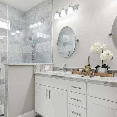 White themed bathroom with gray marble shower and modern cabinets