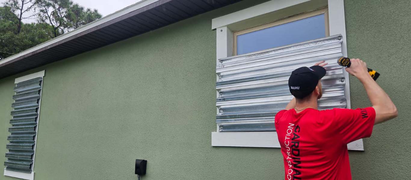 Cardinal Construction worker installing hurricane shutters